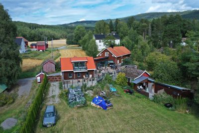 Fotografi av en bolig og tomte med omgivelser sett fra luften.