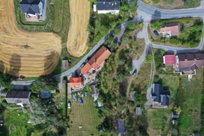 Luftfoto av et boligfelt med flere hus, veier og jordbruksarealer.