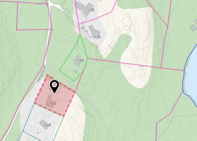 Kart med topografiske linjer, eiendomsgrenser (fargekodet), veier og et lokaliseringssymbol som markerer en spesifikk eiendom.