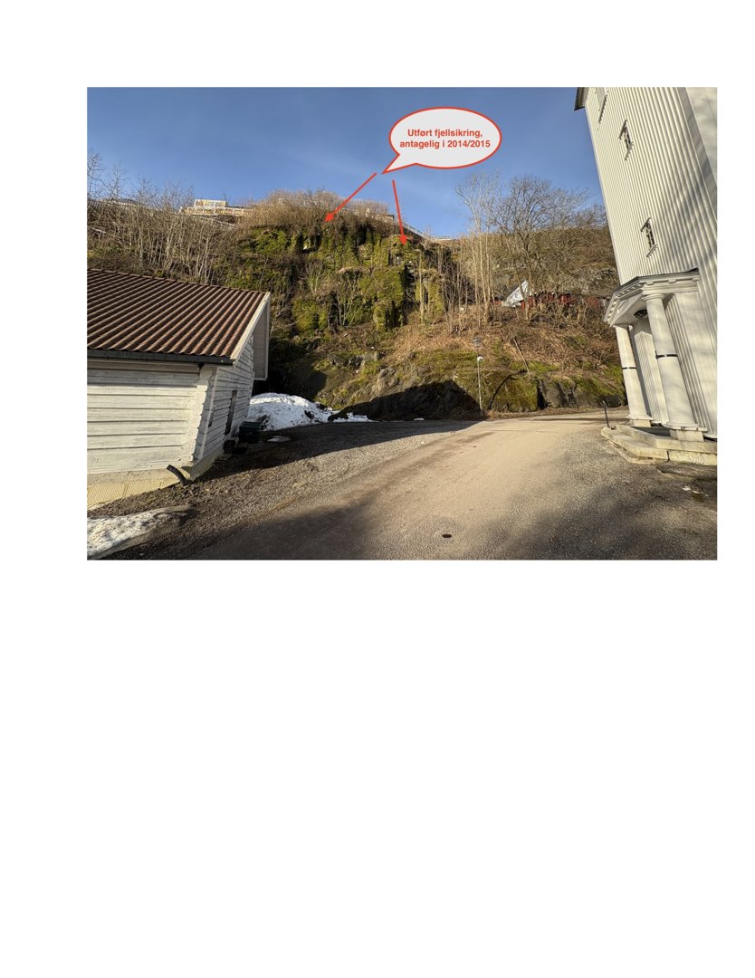 Fotografi av en bygning og en bratt fjellside med en markering som peker på en fjellsprengning.