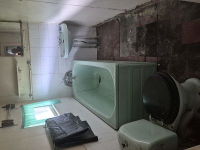 Fotografi av et gammelt bad med badekar, vask og toalett.