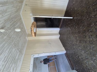 Fotografi av en tom inngangsparti eller gang i et hus med gulvbelegg og tapet som skal rives.