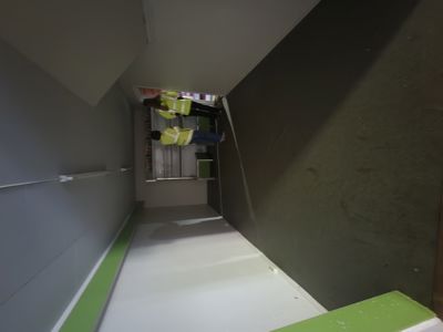 Fotografi av en gang eller trappetårn under bygging, med to personer i sikkerhetsvester som ser ut til å inspisere arbeidet.