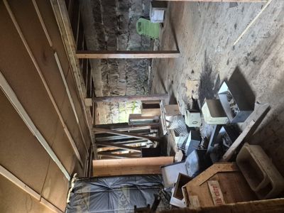 Fotografi av et uordnet rom inne i en bygning, sannsynligvis under ombygging eller renovering.