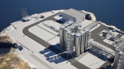 3D-visualisering av et industrielt anlegg (sannsynligvis en kjernekraftstasjon) sett fra luften, med omgivende terreng og hav.