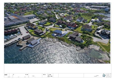 Luftfoto av et boligområde ved kysten med flere hus, veier og vann.