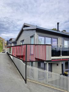 Fotografi av en moderne villa sett fra siden, med en tegnet balustrade overlagt på bildet.