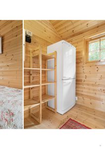 Fotografi av et innvendig rom med trepanelvegger og -gulv, inneholdende en hvit kjøleskap og et trehyll. Bildet viser en eksisterende eller ferdigstilt tilstand.