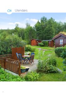 Fotografi av en utendørs hage med hytter, terrasse og møbler.