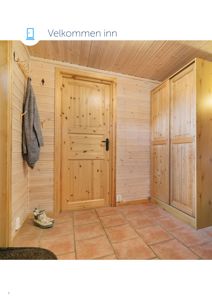 Fotografi av en innvendig inngangsparti med trepanelvegger, flisgulv og en garderobe.