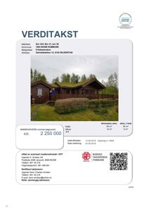 Fotografi av en hytte med grønt tak, omgitt av busker og trær.