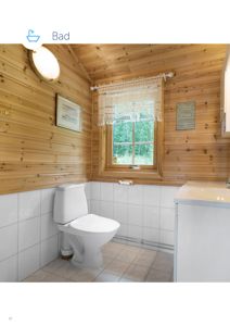 Fotografi av et bad med trepanelvegger, hvite fliser og sanitæranlegg.