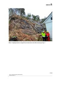 Fotografi av en bergskrent med vegetasjon og arbeidere i sikkerhetsutstyr ved siden av en bygning.