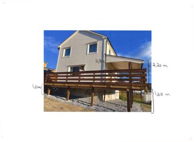 Fotografi av en bygning med en utvendig terrasse, med håndskrevne mål på bildet.