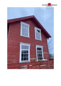 Fotografi av en rød trebygning sett fra siden, med synlige vinduer og fasade.