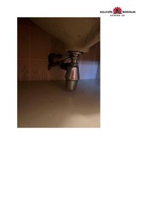 Fotografi av en vaskesiphon og rør under en vask i et bad.