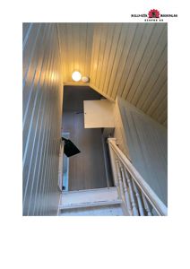 Fotografi av en trapp og etasjehøyde med panelvegger og tak