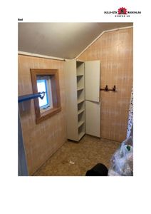 Fotografi av et bad med flisete vegger, et skap og et vindu.