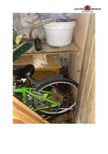 Fotografi av en liten, utilpasset oppbevaringsplass inne i et bygg (kanskje garasje eller kjeller) med sykkel, hylle og diverse gjenstander.