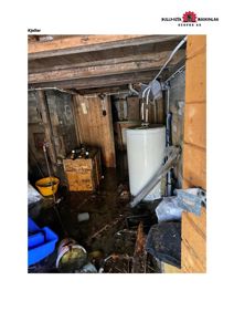 Fotografi av en kjellerrom med synlig vannskade, møbler og teknisk utstyr.