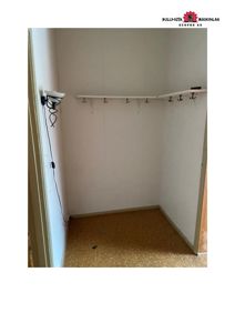 Fotografi av en tom garderobe eller skap med innbygget stang og henger.