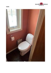 Fotografi av et toalettrom med rødvegg, hvittoalett og vindu.