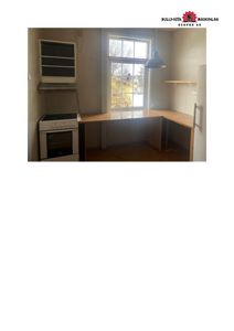 Fotografi av en tom kjøkkenrom med innredning (ovn, benkeplate, vindu).