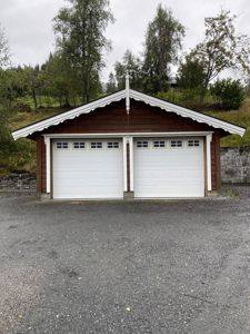 Fotografi av en ferdigbygd garasje med to dører, sett fra foran.