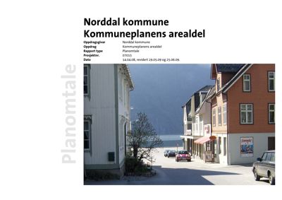 Fotografi av en gate i Norddal kommune med bygninger og fjord i bakgrunnen.