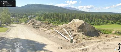 Fotografi av et byggefelt med grøfting og jordsmonn, sett fra en vei.