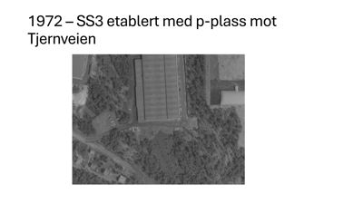 Et gammelt, svart-hvitt flyfoto fra 1972 som viser en bygning (SS3) med en p-plass mot Tjernveien.