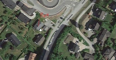 Flyfoto eller kartutsnitt som viser et boligområde med veier og hus.