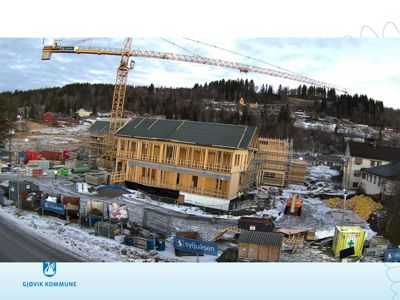 Fotografi av et bygg under oppføring på en byggeplass med snø på bakken.