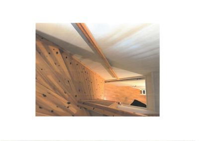 Fotografi av en innendørs trapp eller gang med trepanelvegger og et tak med en lysende lampe.