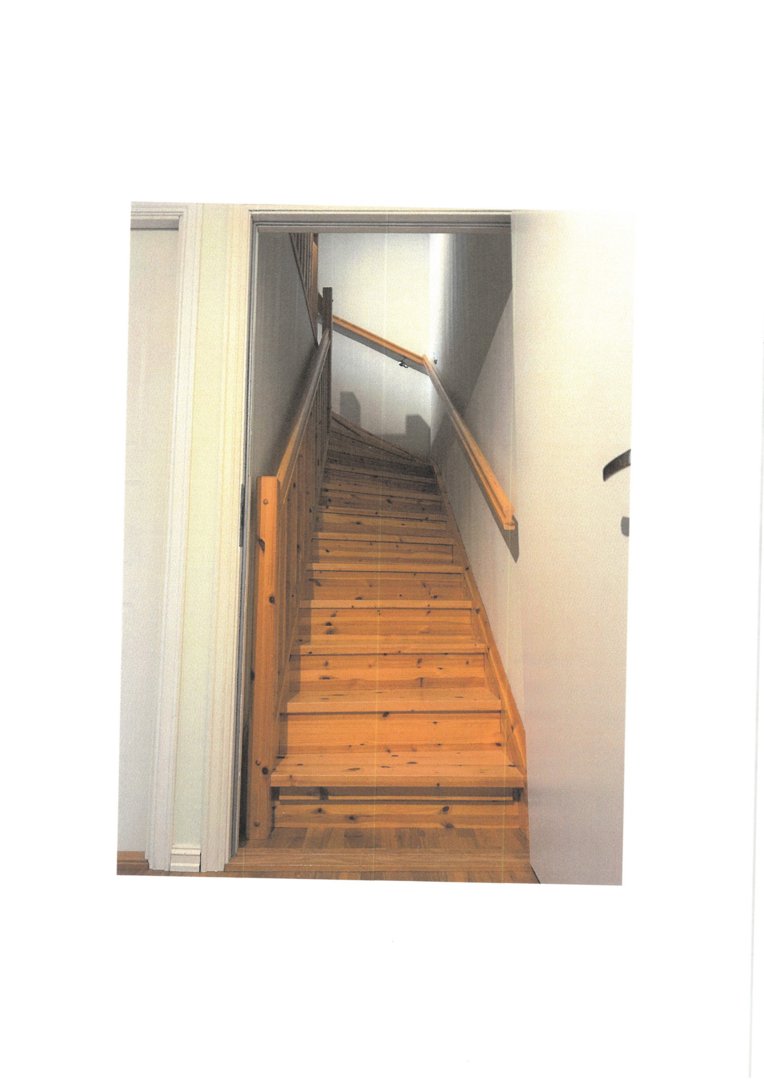 Fotografi av en trapp i en bygning, sett fra nederst og oppover mot etasjen over.