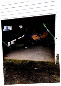 Fotografi av en garasjeport med en båt stående inne i garasjen.