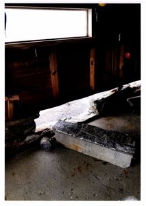 Fotografi av en skadet betongkonstruksjon (sannsynligvis et fundament eller en trapp) inne i en bygning.