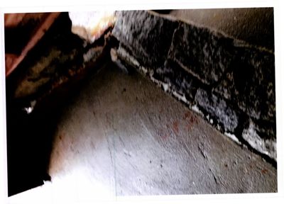 Fotografi av en vinkel i en bygning, som viser mønstersteinvegg og gulv.