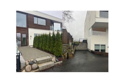 Fotografi av en moderne bolig med fasade, vinduer, trapp og hageanlegg.