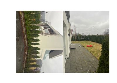 Fotografi av en moderne villa sett fra utsiden, med en del av hagen og en oppkjøringsvei i forgrunnen.