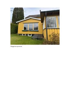 Fotografi av en gul bygning med en tilbygget stue og veranda.