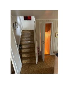 Fotografi av en trapp og et inngangsområde i en bygning.