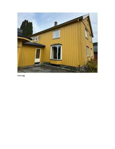 Fotografi av en gul, toetasjes trehus sett fra siden (vestveggen).