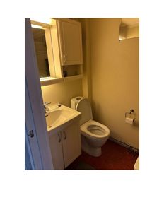 Fotografi av et bad med hvit innredning, gulv og gule vegger.