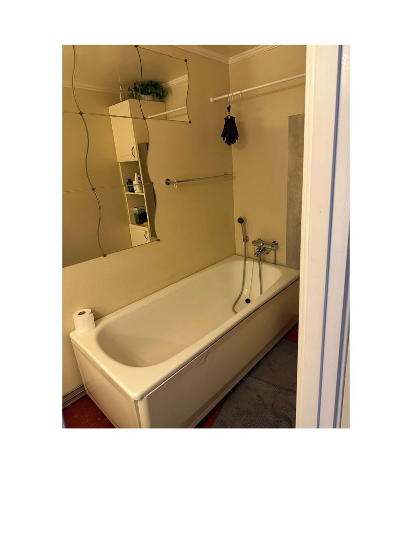 Fotografi av et bad med badkar, speil og innredning.