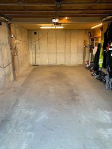 Fotografi av en garasje eller kjellerrom med betongvegger og gulv.