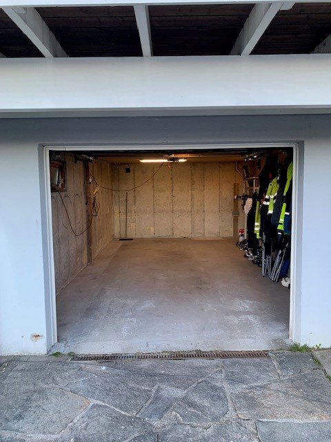 Fotografi av en garasje eller kjellerrom med en åpen dør.