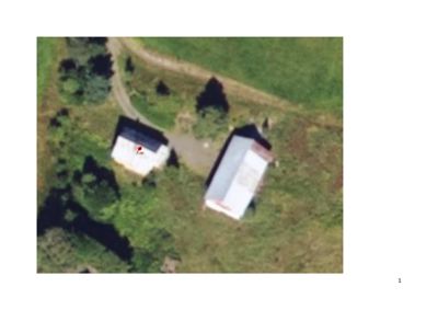 Luftfoto (satellittbilde) av to bygninger på en tomt med vegetasjon og en vei.