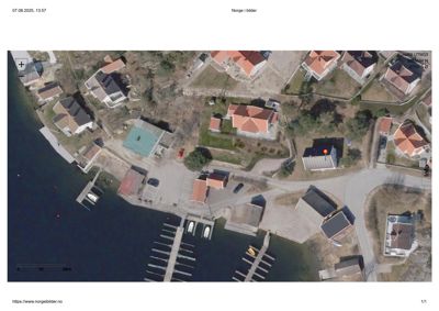 Flyfoto fra Norgebilder som viser et nabolag med hus, brygger og vann.