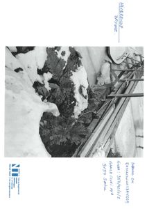 Et svart-hvitt fotografi av en bygning med snø på taket og en takterrasse.